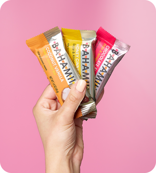 BahamaHi snack bars hand coconut vanilla honey cinnamon chocolate pink background